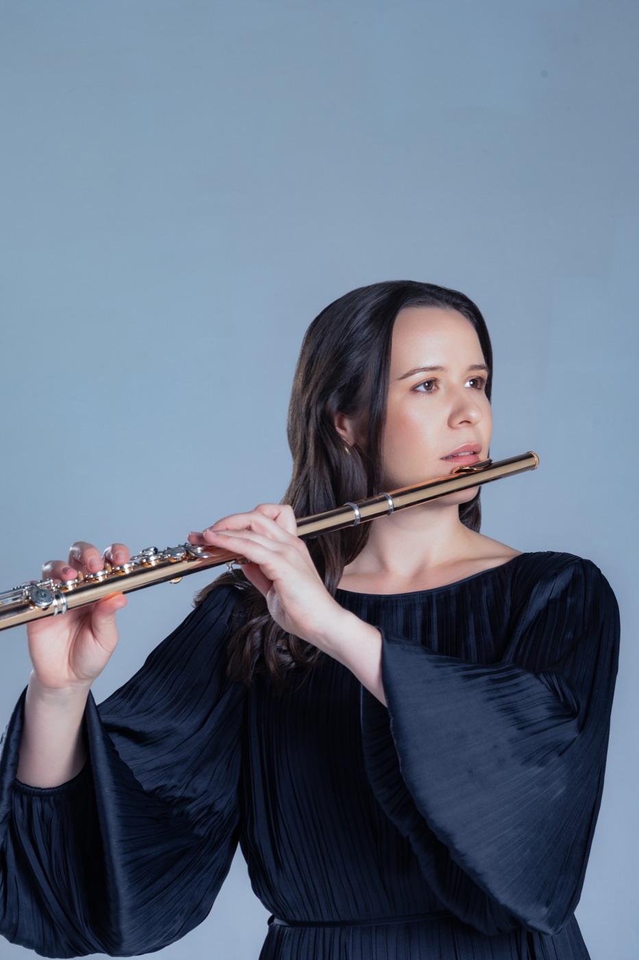 Lauren playing the flute in a black dress